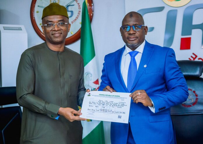Executive Chairman, FIRS, Muhammad Nami with Deputy Managing Director, NLNG, Mr. Olalekan Ogunleye showing Tax Credit Certificate handed to NLNG for the construction of the Bonny - Bodo Road and Bridge, Rivers State. August 18, 2022.